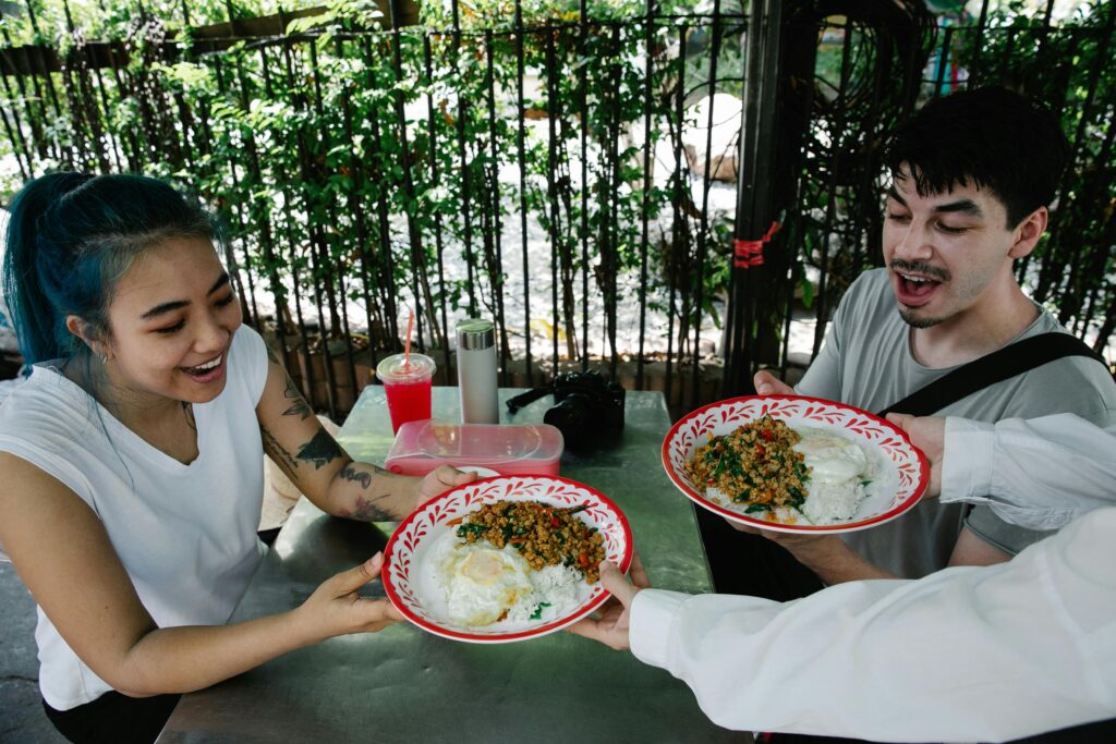 Plate of Pad Kra Pao, a popular Thai stir-fried dish with basil, chili, and meat, served with rice and a fried egg on top.