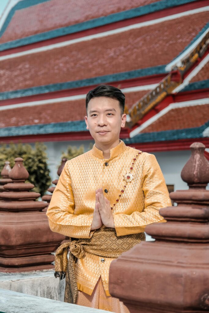 Person performing the Thai wai gesture with palms pressed together and a slight bow, symbolizing respect and greeting.